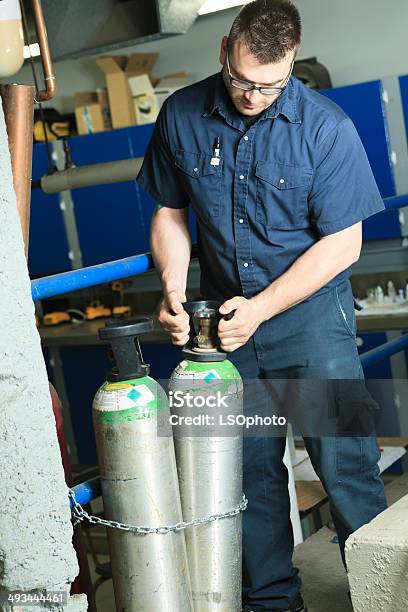 Serviceman Oxygen Bottle Vertical Stock Photo - Download Image Now - Adult, Basement, Blue-collar Worker