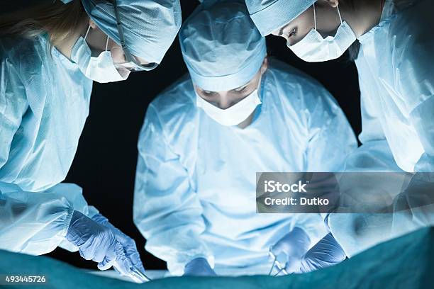 Medical Team Performing Operation Stock Photo - Download Image Now - Surgeon, Females, Operating Room