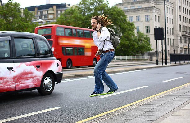 On the phone riding a hoverboard Man talking on the phone whilst riding a hoverboard across Waterloo Bridge as a black cab and bus drive by. waterloo bridge stock pictures, royalty-free photos & images