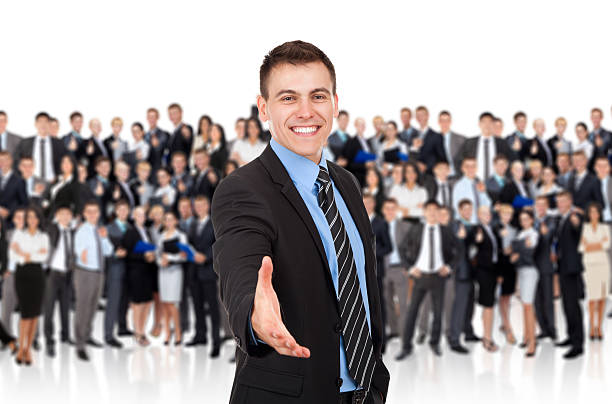 businessman handshake, group of people businessman handshake, hold hand welcome gesture, Handsome young excited business man happy smile shake hand over big group of businesspeople crowd background cheering group of people success looking at camera stock pictures, royalty-free photos & images