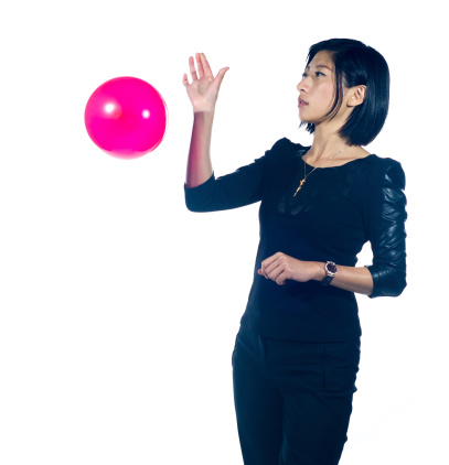 A young Asian woman posing against a white background with a balloon