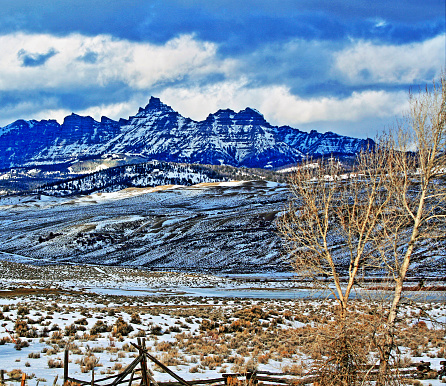 Sublette Peak on Togwotee Pass in the Absaroka Mountains during the winter in Wyoming USA with impending cumulus clouds looming over.  This is the mountain pass between Dubois Wyoming and the Grand Tetons National Park / Jackson Hole (valley) where the Absaroka and Wind River mountain ranges of the Rockies meet