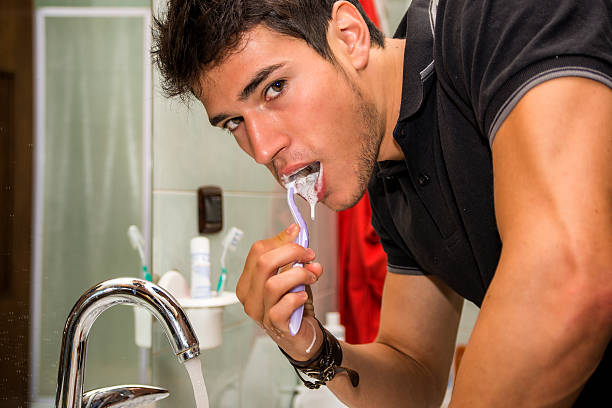 化の魅力的な若い男性歯みがき - smiling human teeth toothbrush moving up ストックフォトと画像