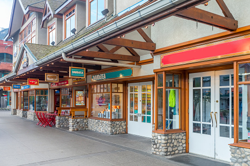 Tourists and visitors on the street enjoying the hotels, restaurants and retail facilities of the town of Banff in Banff National Park in Canada.