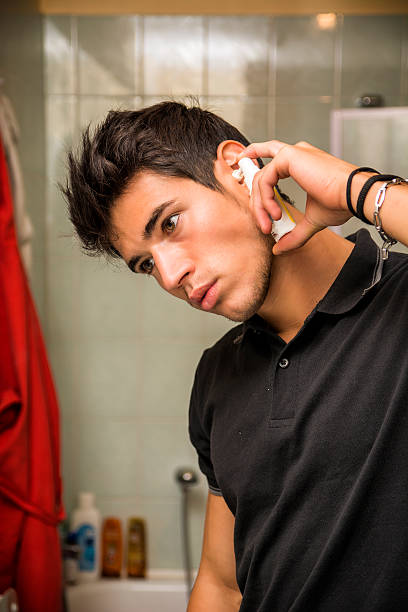 istock Young Man Spraying Ear Spray into Ears 493474444