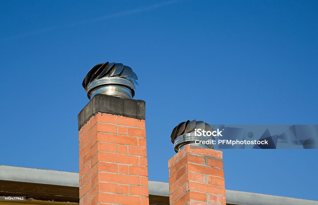 Chimney Caps Two Chimney Caps with blue sky as background Chimney Stock Photo