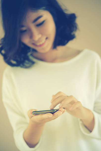 istock asia young beautiful lady touching and browsing her smart phone 493479572
