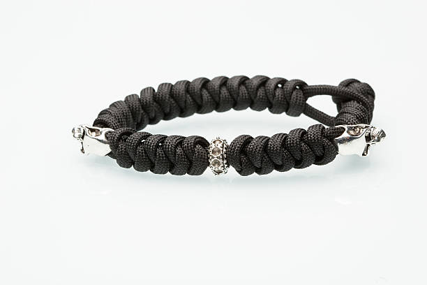 istock Black braided bracelet with skulls on white background 493482120