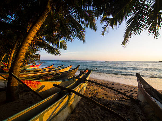 Beautiful sunrise on Morondava Beach on the west coast of the African island nation of Madagascar in the Indian Ocean. The hand made boats are used by local fisherman that are set out into the sea each morning.
