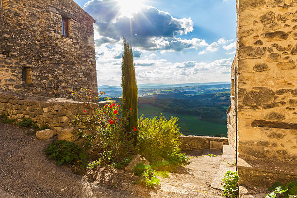 Lurs, Provence, France Fabulous view from the well restored 612m high situated medieval provencial village, overlooking the Durance valley. Cypress tree and red roses in front. lur stock pictures, royalty-free photos & images