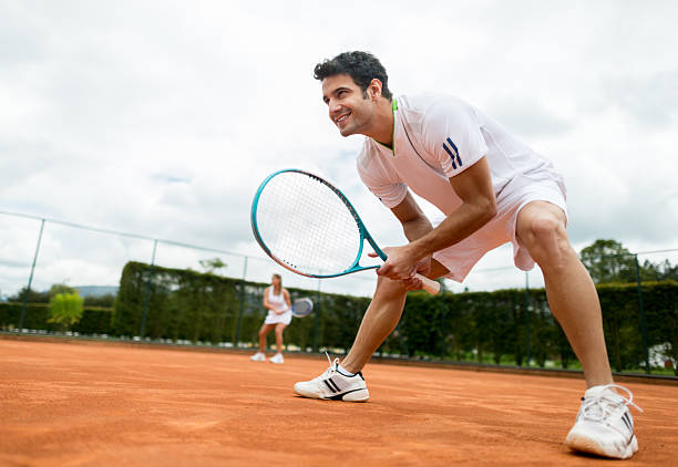 uomo giocare a tennis - doppio foto e immagini stock