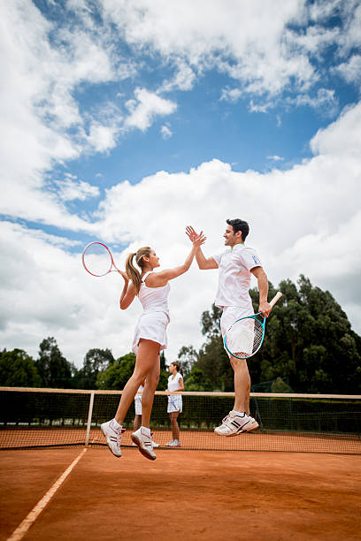 couple winning a tennis match - tennis serving men court 뉴스 사진 이미지