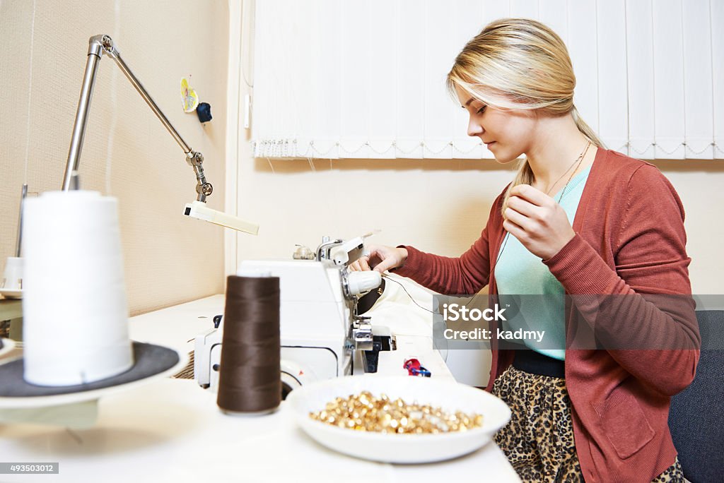 female tailor at work female tailor working with sewing machine and cloth in workshop 2015 Stock Photo