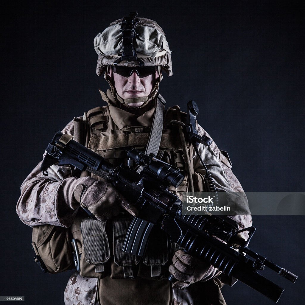 US marine studio shot on black background US marine with his assault rifle on black background Aggression Stock Photo