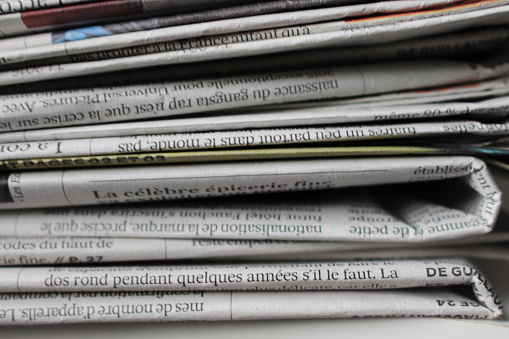 This is a photograph of newspapers stacked one on the other.