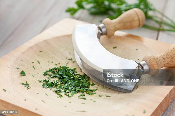 Fresh Parsley On A Board With Mezzaluna Stock Photo - Download Image Now - 2015, Bunch, Chopped Food