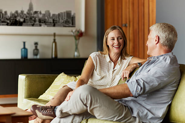 couple spending leisure time in living room - women couple men talking foto e immagini stock