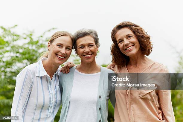 Happy Mature Women Standing In Park Stock Photo - Download Image Now - Only Women, Friendship, Happiness