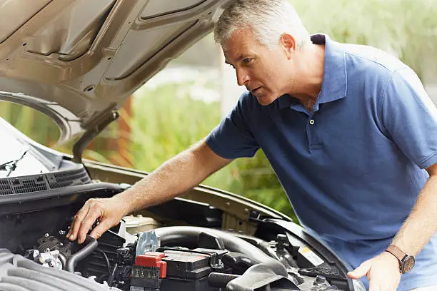 Photo of Man fixing his car engine