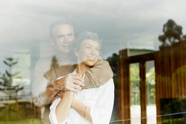 Photo of Thoughtful couple looking through window