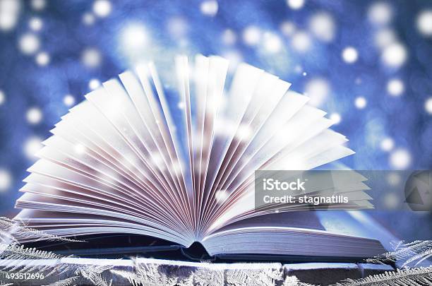 Winter Story Open Book On Wooden Snowy Blue Background Stock Photo - Download Image Now