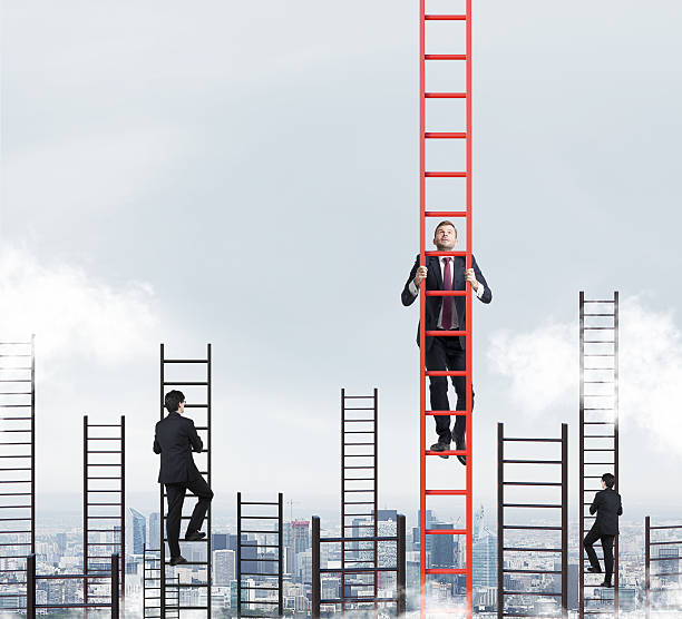 istock businessmen are racing to achieve the highest point using ladders 493514422