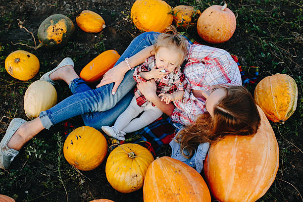 istock mother and daughter lie between pumpkins 493514464