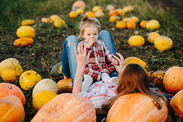 istock mother and daughter lie between pumpkins 493514662