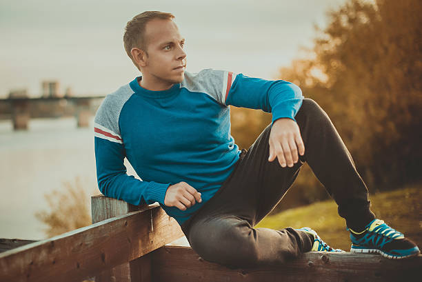 istock Attractive man sitting on beach in the evening  after sport. 493516310