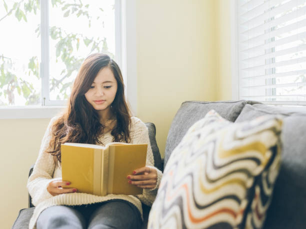 istock asian woman reading at home 493532240