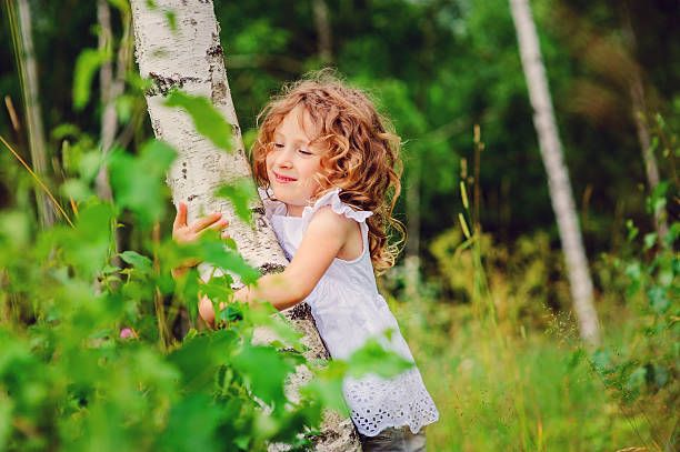 adorable child girl exploring nature in summer forest