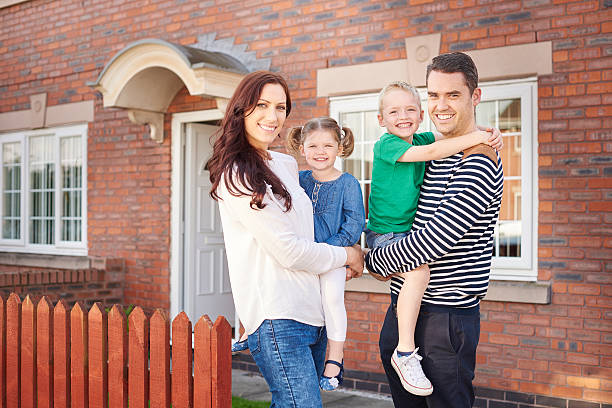 istock young family outside their home 493532540