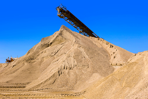 conveyor at the gravel pit with gravel mountain