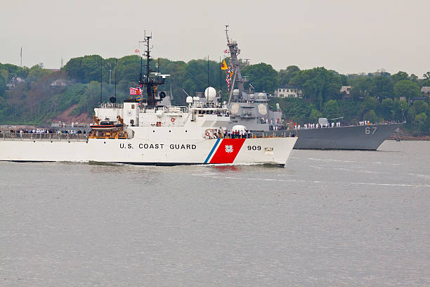 A ship that will be anchored to the port, moves slowly accompanied by a guide ship behind it.