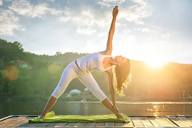 Photo of Woman doing yoga on the lake - beautiful lights