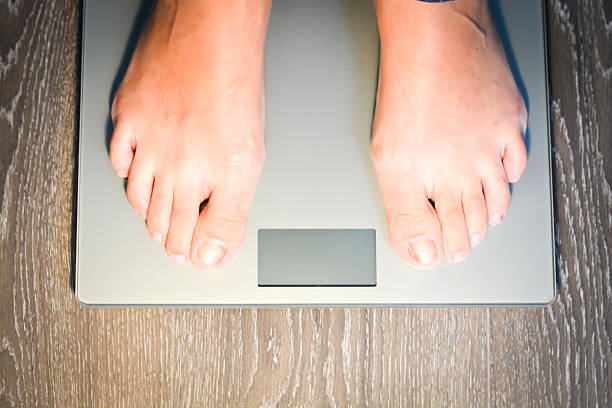 istock Lose weight concept with person on scale measuring kilograms 493537164