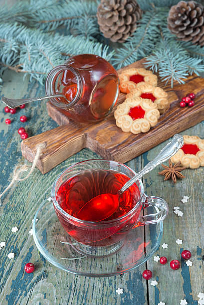 Cup of tea Hot tea in a transparent cup, jam and cookies on a background of Christmas decorations pine needle tea stock pictures, royalty-free photos & images