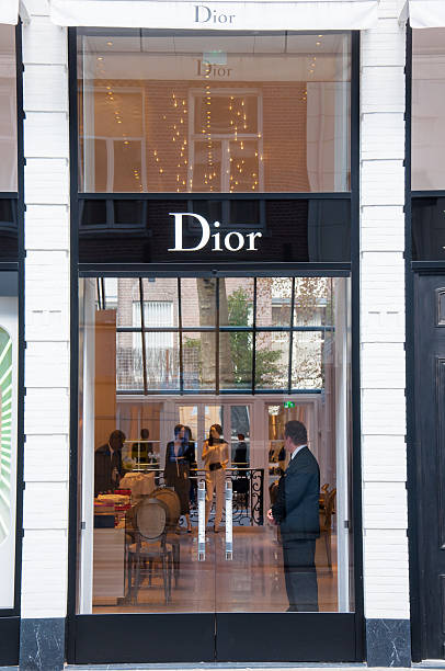 Dior store in the expensive and posh P.C.Hooftstraat shopping street. Amsterdam, the Netherlands - April 30, 2015: Dior store in the expensive and posh P.C.Hooftstraat shopping street, people on the shop. victoria beckham stock pictures, royalty-free photos & images