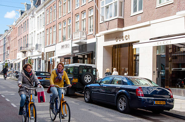 The P.C.Hooftstraat fashion street with the world biggest brands. Amsterdam. Amsterdam, the Netherlands - April 30, 2015: The P.C.Hooftstraat fashion street with the world biggest brands, people ride a bike. victoria beckham stock pictures, royalty-free photos & images