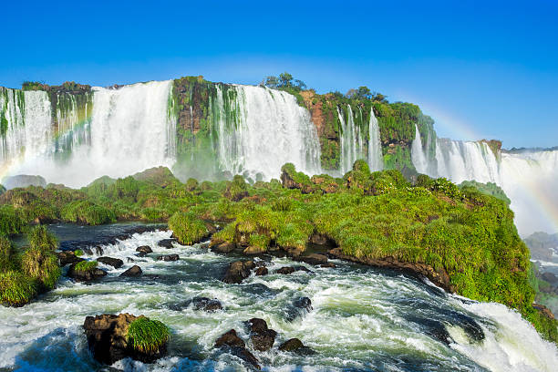 cataratas do iguaçu, na fronteira da argentina, brasil e paraguai - tropical rainforest waterfall rainbow iguacu falls - fotografias e filmes do acervo