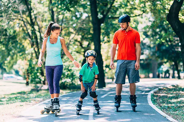 Family of three roller skating in the park