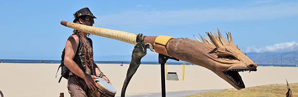 Venice, California, USA - July 11, 2015: A street musician plays an Australian dragon head didgeridoo on the Venice Beach Boardwalk.