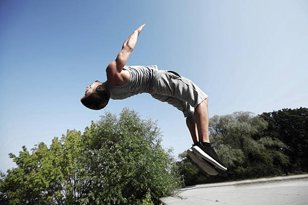 istock sporty young man jumping in summer park 493550222