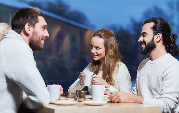 istock happy friends meeting and drinking tea or coffee 493550398