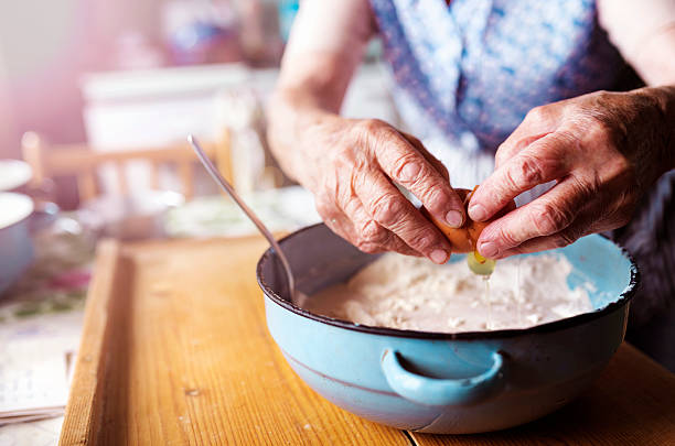 donna anziana cuocere al forno - grandmother senior adult family domestic kitchen foto e immagini stock