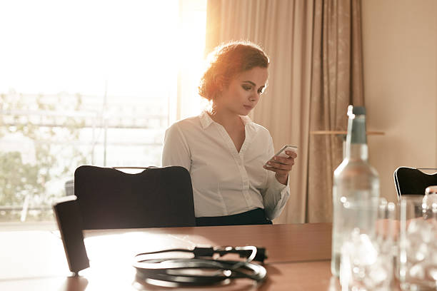 istock Businesswoman at conference table using mobile phone 493552722