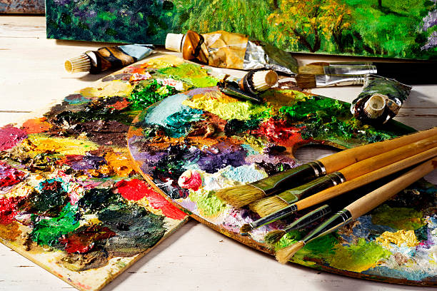 palette with paintbrushes and canvas  paintings stock photo