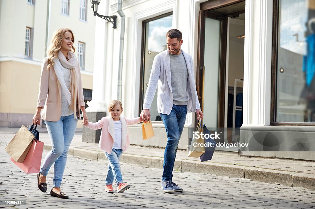 happy family with child and shopping bags in city sale, consumerism and people concept - happy family with little child and shopping bags in city Family Stock Photo