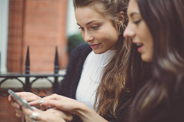 Fancy women in London using a mobile phone