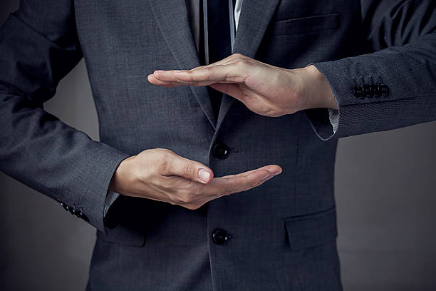 istock Businessman in suit with two hands protecting something 493555390